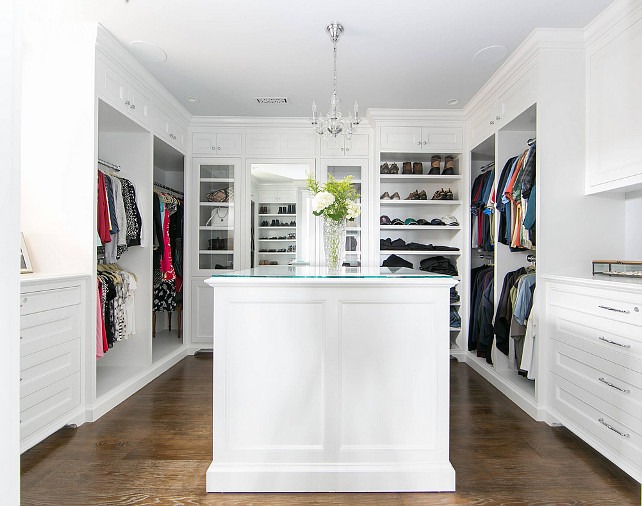 U shaped closet with white built-in cabinets